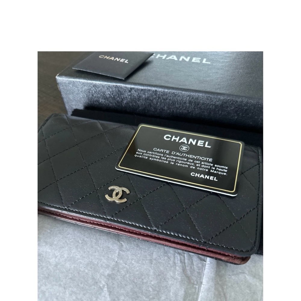 Classic black channel long leather wallet with card slots and a zippered pouch.